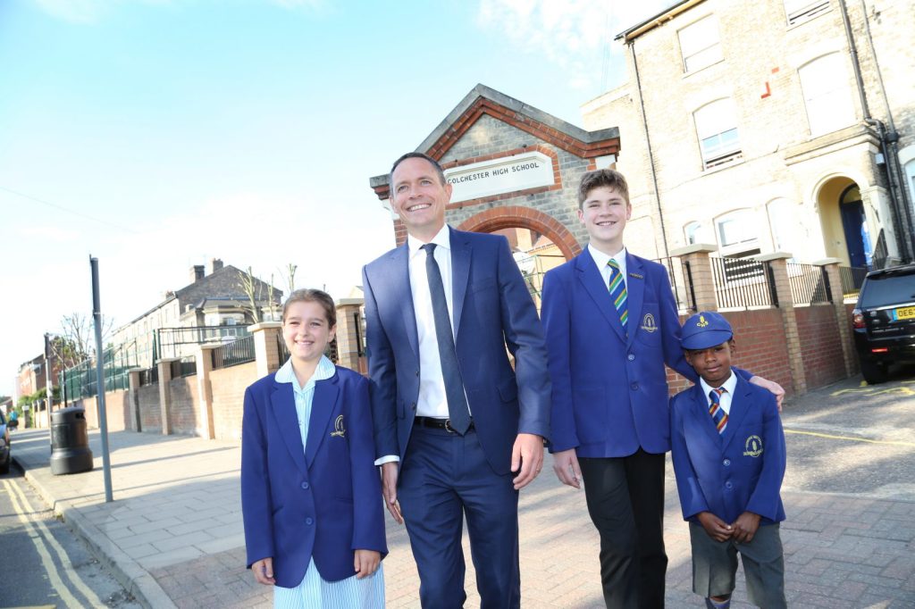 Headmaster walks with pupils across the school courtyard